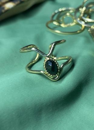 Кольцо с черным камнем в золотистой оправе