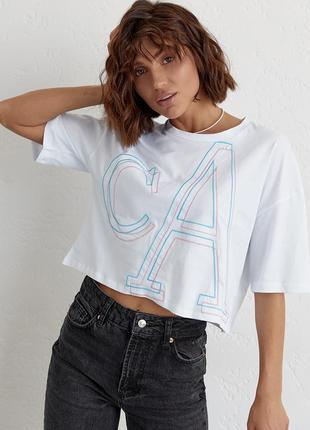 Укороченная женская футболка с вышитыми буквами.