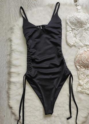 Черный сдельный цельный купальник бикини с вырезом декольте шнуровкой люверсами по бокам5 фото