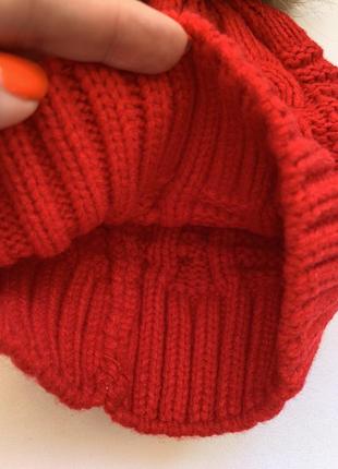 Шапка зимняя вязанная красного цвета с бубоном из меха енота в наличии5 фото