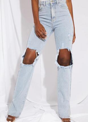 Высокие светло-голубые рваные джинсы с разрезом по низу до колена