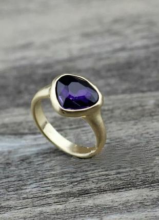 Золотистое кольцо с фиолетовым камнем1 фото