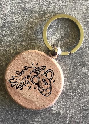 Круглий дерев’яний брелок з зображенням  зодіака «водолій»