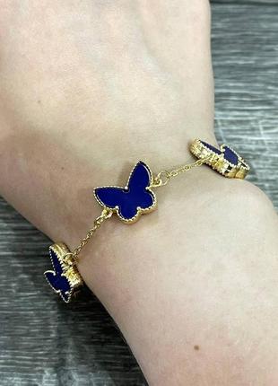 Золотистий жіночий браслет з яскравими синіми метеликами підвісками - оригінальний подарунок дівчині
