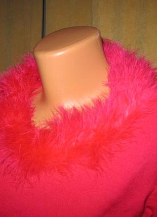 Ярко-розовый свитер со воротником из перьев.