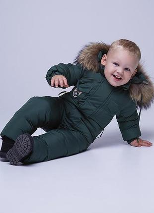 Детский однотонный зимний комбинезон темно-зеленого цвета и опушкой из натурального меха 98 см.
