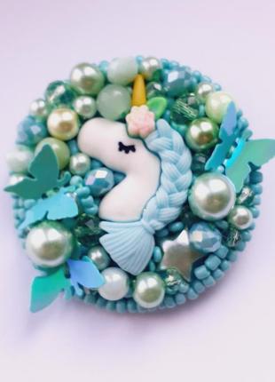 Брошка з єдиноріжкою, розшита намистинами та бісером м'ятного нефритового кольору.