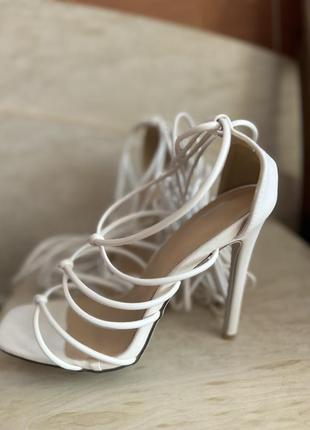 Белые босоножки на шнуровке и высоком каблуке.3 фото