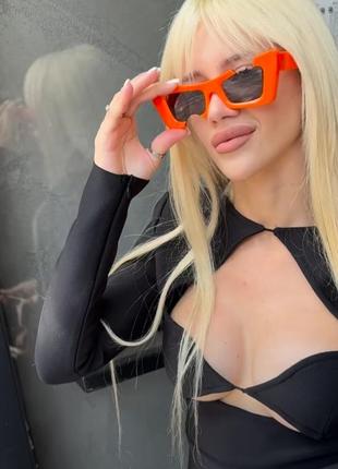 Очки оранжевые, прямоугольные.