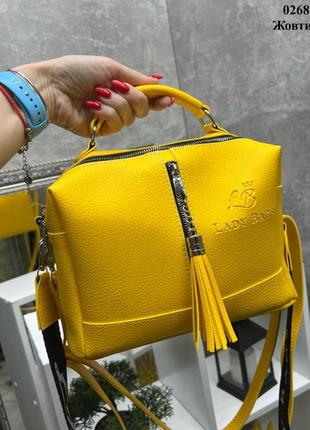 Сумка середнього розміру через жіноче плече з широким ремінцем жовта