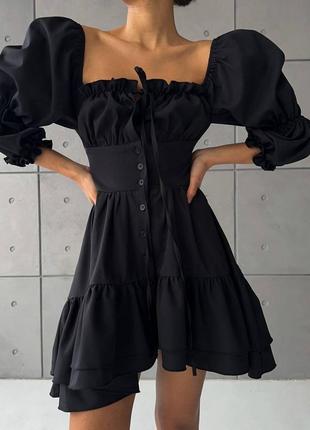 Черное платье мини с открытыми плечами и шнуровкой.