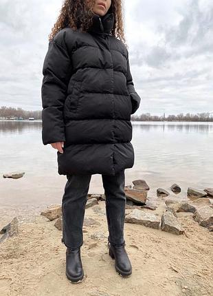 Об'ємний чорний пуховик з кишенями з боків