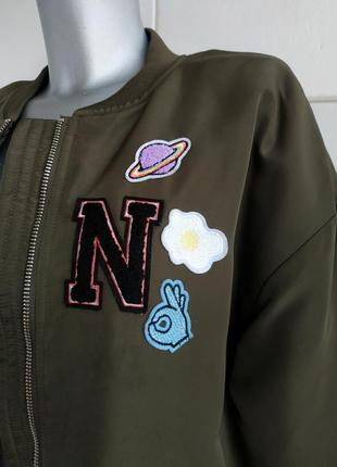 Стильна подовжена куртка-бомбер h&m кольору хакі з нашивками7 фото