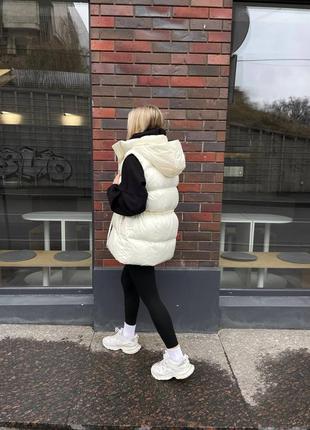Жилетка удлиненная с капюшоном молочная стеганая