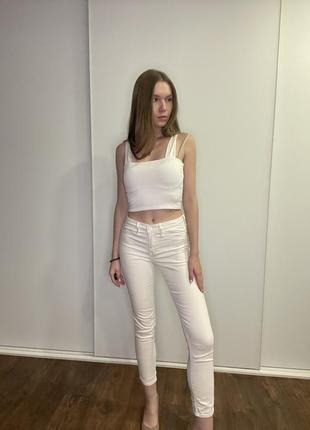 Белые зауженные джинсы