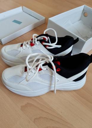 Белые кроссовки с черно-красными акцентами.4 фото