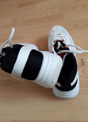 Белые кроссовки с черно-красными акцентами.6 фото