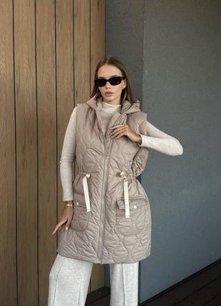 Подовжена жіноча жилетка бежевого кольору, жіноча жилетка з капюшоном та кишенями