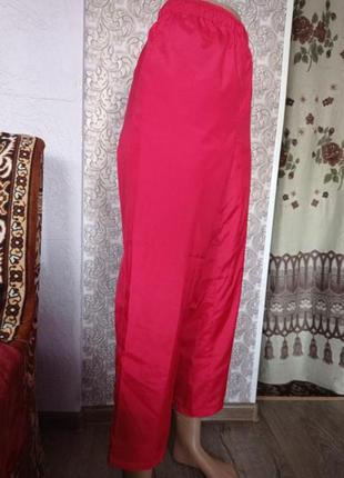 Спортивні штани-плащівка червоного кольору.