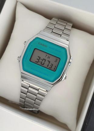 Наручные электронные часы серебристого цвета с синим циферблатом