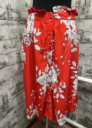 Красная в белых цветах юбка с карманами по бокам под пояс с пуговками спереди1 фото