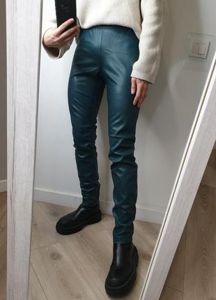 Стильные кожаные брюки скошенные лосины из эко-кожи изумрудного цвета