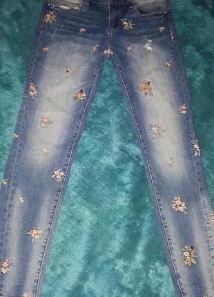 Джинсы роскошные декорированы потертостями вышивкой и сияющими камушками.