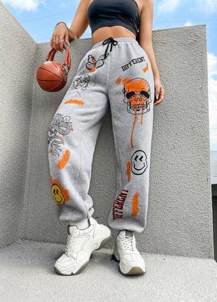 Спортивні штани на флісі з принтом нашивкою спереду на манжетах бежеві сірі джоггери трендові стильні3 фото