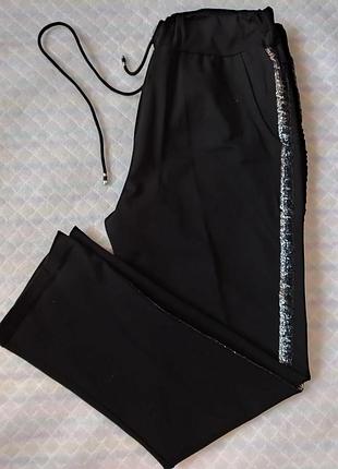 Черные теплые брюки со стразами.