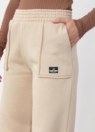 Трикотажные брюки на флисе с накладными карманами бежевые белые черные утепленные с начесом клеш широкие вширенные клешь свободные свободностные брюки6 фото