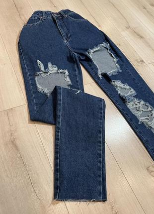 Темно-синие рваные джинсы