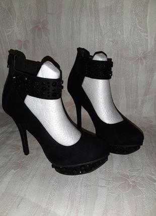 Чёрные туфли на высоком каблуке с чёрными заклёпками и молния на пяточке1 фото
