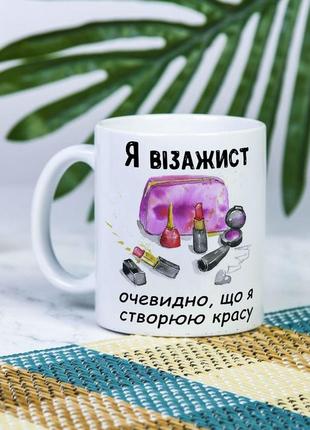 Біла чашка на подарунок з написом "я візажист, очевидно, що я створюю красу" 330 мл