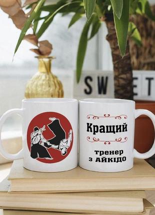 Біла чашка на подарунок з написом "кращий тренер з айкідо" 330 мл