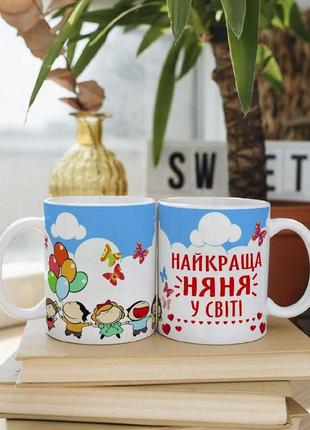 Біла чашка на подарунок з написом "найкраща няня у світі" 330 мл