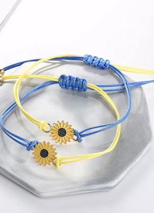 Набор браслетов на затяжках в голубо-желтых цветах флага украины с декором в виде подсолнечника.