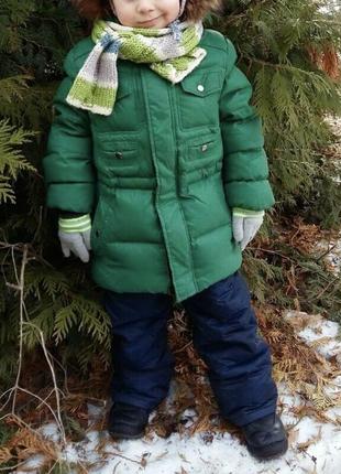 Теплый зимний пуховик зеленого цвета с капюшоном ,опушкой енота на мальчика 4-5 лет
