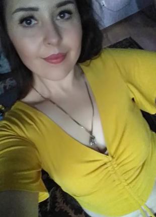 Яскравий топ зі збіркою на грудях