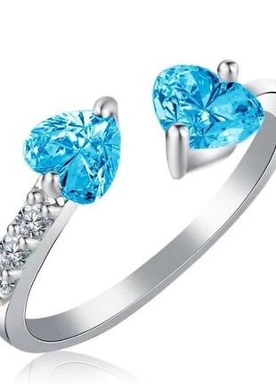 Кольцо серебристое женское покрытое белыми камнями фианитами и камнями голубыми в виде сердца р регулируемый