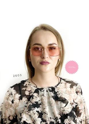 Розовые солнцезащитные очки в золотистой оправе