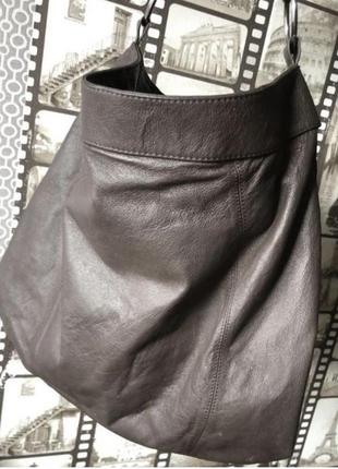 Шоколадного цвета кожаная большая сумка на плечо в руке5 фото
