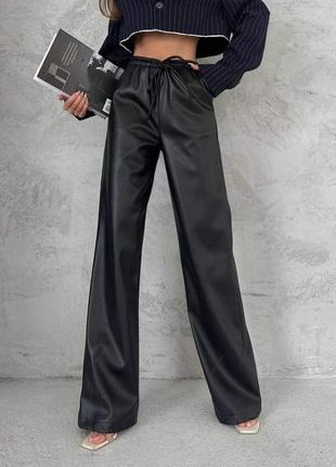 Чорні штани з еко-шкіри в стилі палаццо,на резинці та шнурку,в кулісі є тєсьма для кращої посадки.