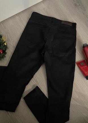 Черные женские джинсы на низкой посадке с вырезами на коленях2 фото