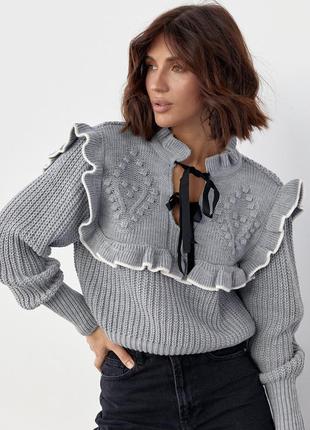 Укорочена в'язана кофта з рюшами та зав'язками