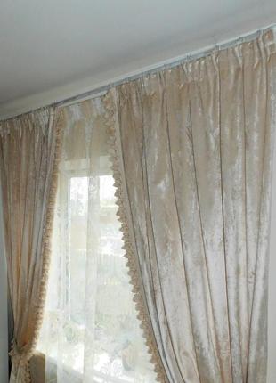 Бежеві оксамитові штори з бахромою.