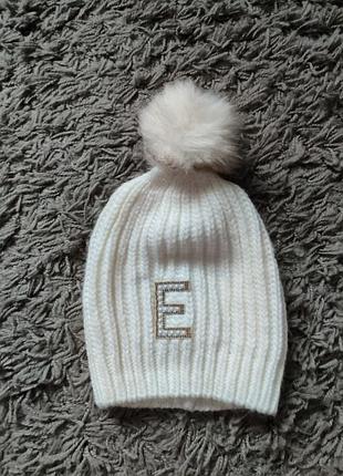 Шапка біла в'язка буква е