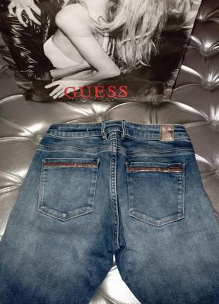 Джинсы guess с лого и украшенны металлическими камнями, которые перелеваються3 фото