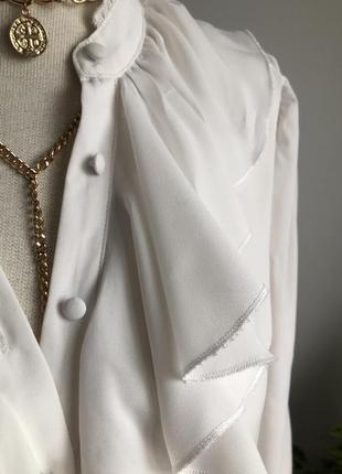 Біла блуза з довгим рукавом і коміром воланом.3 фото