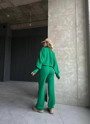 Женский теплый зеленый брючный костюм: укороченная кофта и широкие брюки трубы3 фото