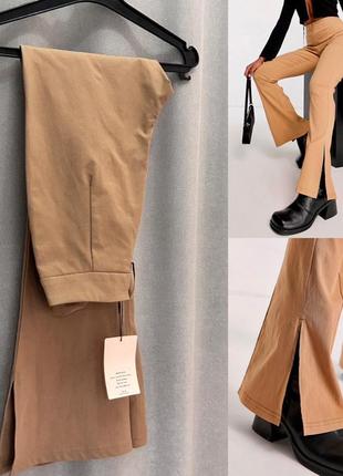 Бежевые брюки клеш с разрезом внизу